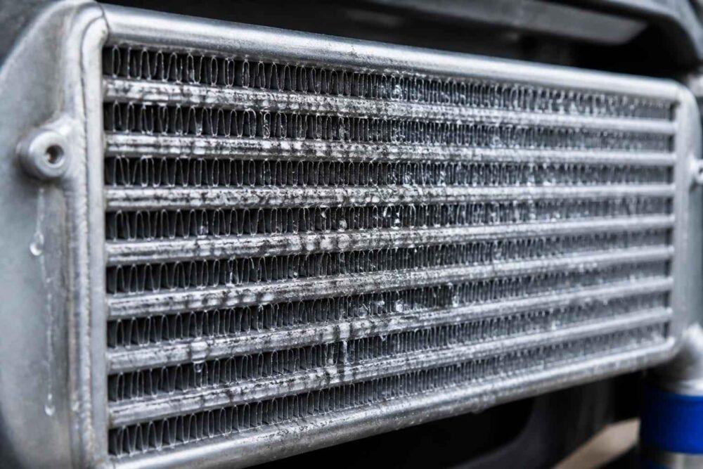 Zbliżenie na aluminiowy intercooler z widocznymi żeberkami chłodzącymi