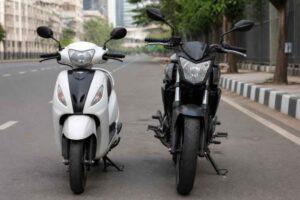 Biały skuter i czarny motocykl zaparkowane obok siebie na ulicy w mieście