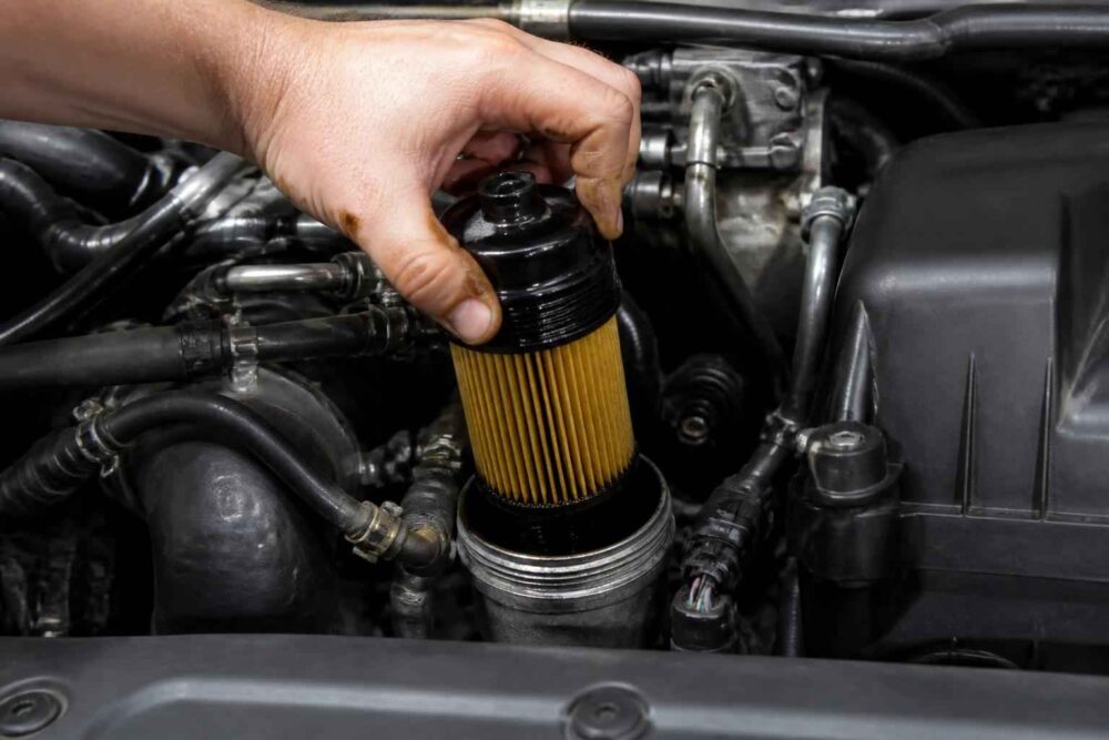 Mechanik umieszcza nowy filtr oleju w obudowie silnika samochodowego