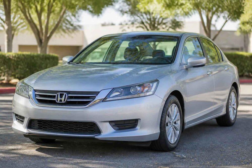 Srebrna Honda Accord zaparkowana w słoneczny dzień przy zielonych drzewach